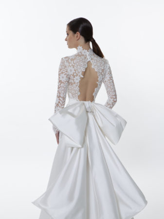 Close up of Valentini Spose V1270 long sleeve lace wedding dress back showing the open back and removable mikado bow train