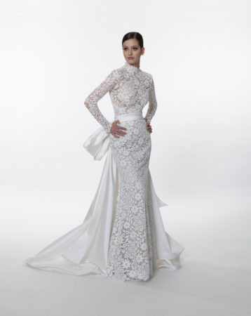 Full front view of the Valentini Spose V1270 long sleeve lace wedding dress with a high neckline, long sleeves and removable mikado train