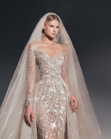Zuhair Murad fall 2022 katya wedding dress at dimitras bridal in chicago featuring a fully beaded tulle long sleeve sheath bridal gown with off the shoulder sweetheart neckline and a matching beaded tulle overskirt and veil
